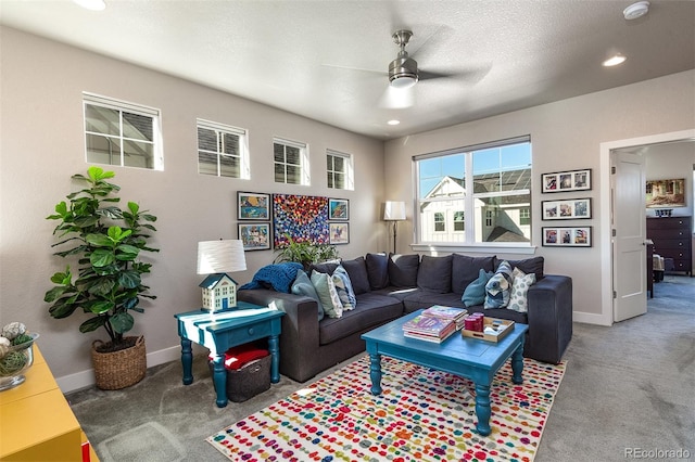 living room with carpet, ceiling fan, and a textured ceiling