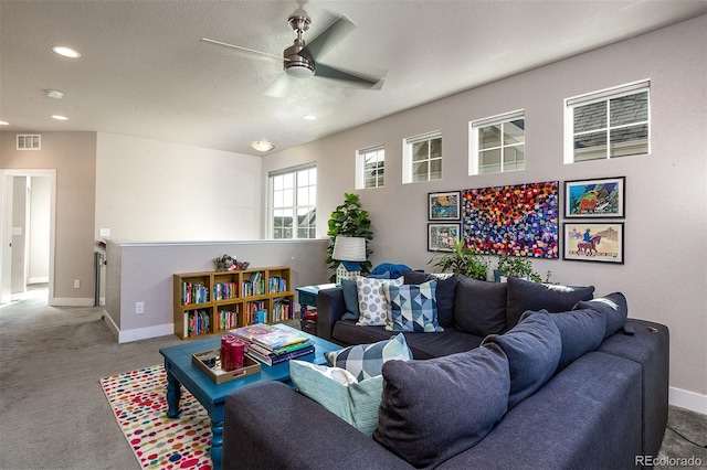 living room featuring carpet flooring, ceiling fan, and a textured ceiling