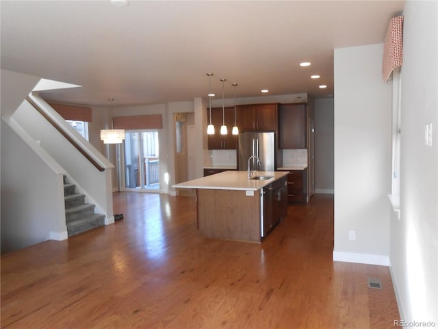 kitchen featuring dark hardwood / wood-style floors, sink, an island with sink, and stainless steel appliances