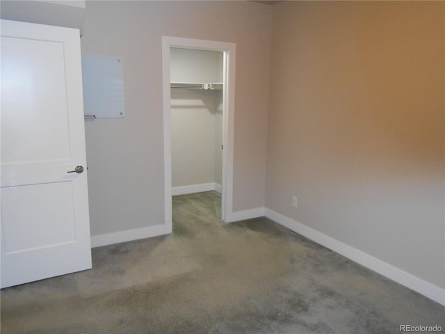 unfurnished bedroom featuring a walk in closet, light carpet, and a closet