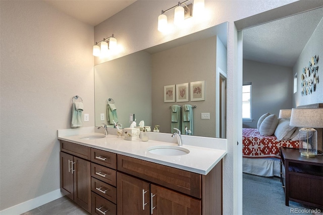 bathroom featuring a textured ceiling, vanity, and vaulted ceiling