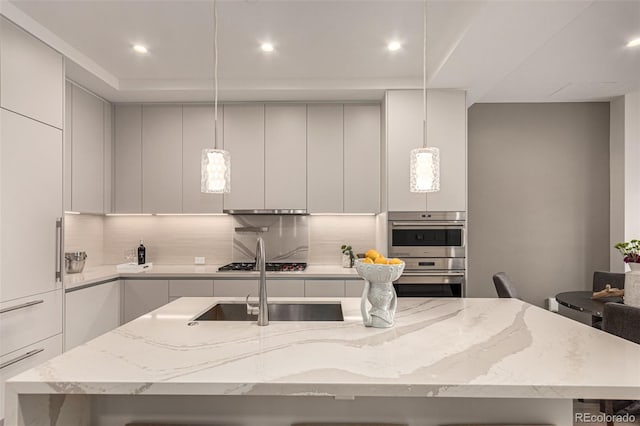 kitchen with tasteful backsplash, appliances with stainless steel finishes, a kitchen island with sink, a sink, and modern cabinets