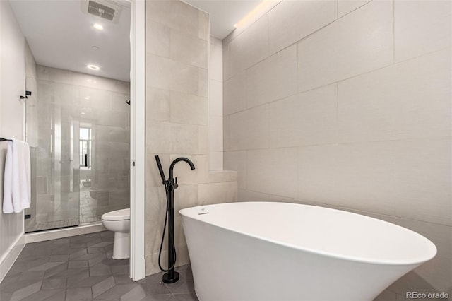 full bathroom featuring tile walls, visible vents, toilet, a stall shower, and tile patterned floors