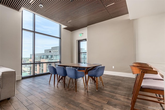 dining area with baseboards, wood finished floors, and floor to ceiling windows