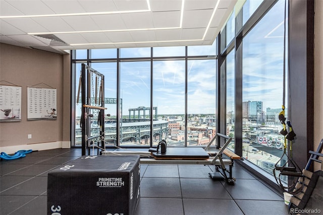 workout area with a view of city, expansive windows, and visible vents