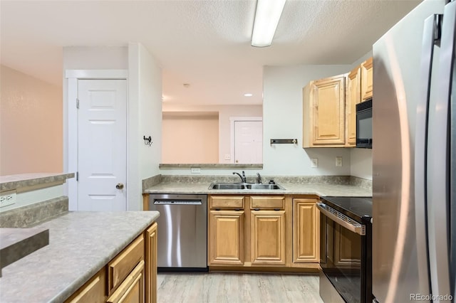5201 S Fox St Unit 102, Littleton, CO 80120 - kitchen with stainless steel appliances, light wood finished floors, and light countertops