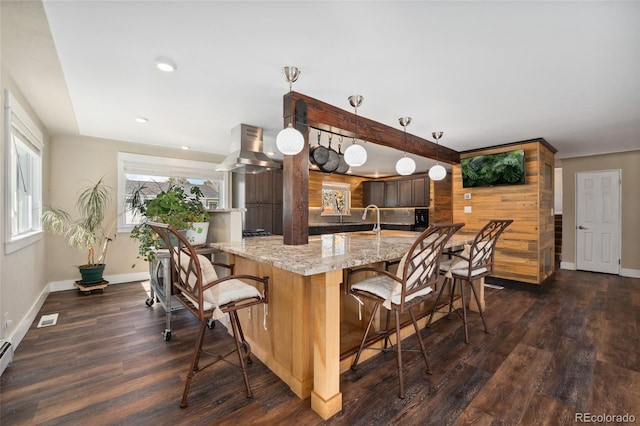 kitchen featuring dark wood-type flooring, a breakfast bar area, and visible vents