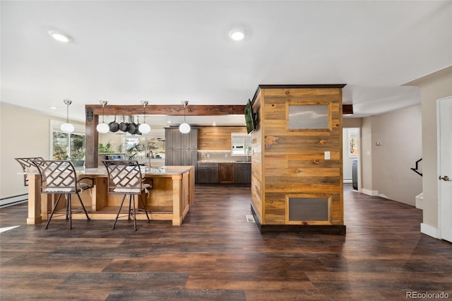 kitchen with dark wood-type flooring, recessed lighting, light countertops, and a kitchen bar