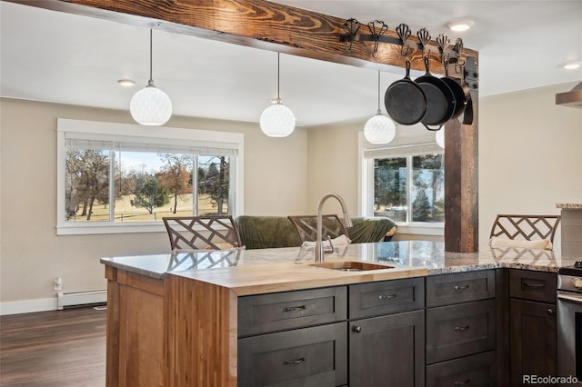 kitchen featuring dark wood-style floors, plenty of natural light, a baseboard heating unit, and a sink