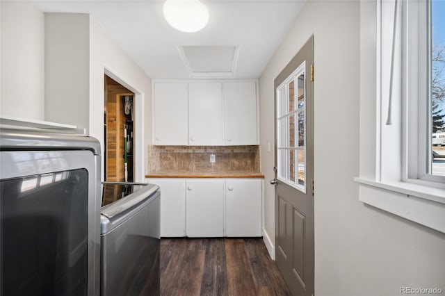 laundry area with dark wood-type flooring, washer and clothes dryer, cabinet space, and attic access