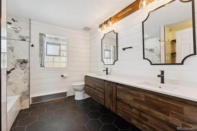 bathroom featuring visible vents, a shower, and a sink