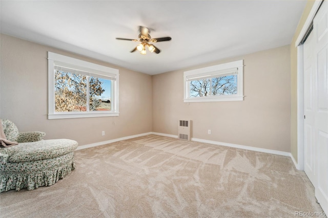 living area with carpet, ceiling fan, and baseboards