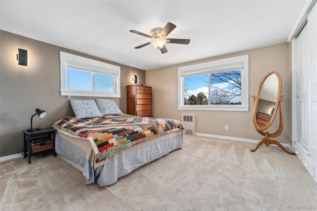 carpeted bedroom featuring baseboards, multiple windows, ceiling fan, and radiator heating unit