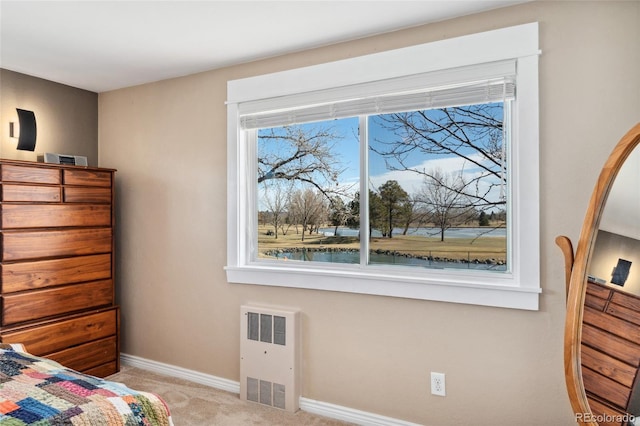 bedroom featuring radiator heating unit, baseboards, and light colored carpet