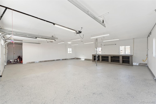 garage featuring a garage door opener and baseboards