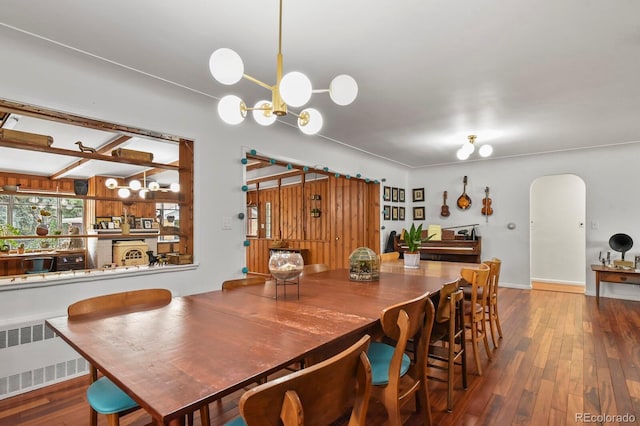 4040 Cody St, Wheat Ridge, CO 80033 - dining room featuring radiator, arched walkways, wood finished floors, and a chandelier
