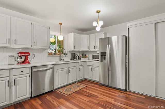 4040 Cody St, Wheat Ridge, CO 80033 - kitchen featuring appliances with stainless steel finishes, white cabinetry, dark wood-style flooring, and light countertops