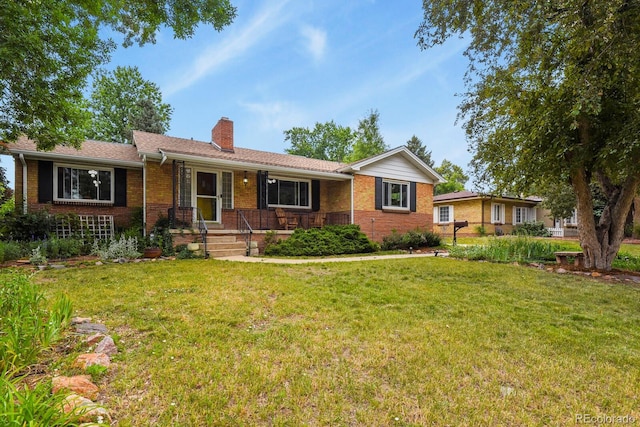 4040 Cody St, Wheat Ridge, CO 80033 - ranch-style home featuring brick siding, a porch, and a front yard