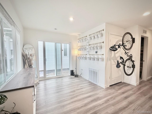 unfurnished living room with visible vents, recessed lighting, light wood finished floors, and baseboards