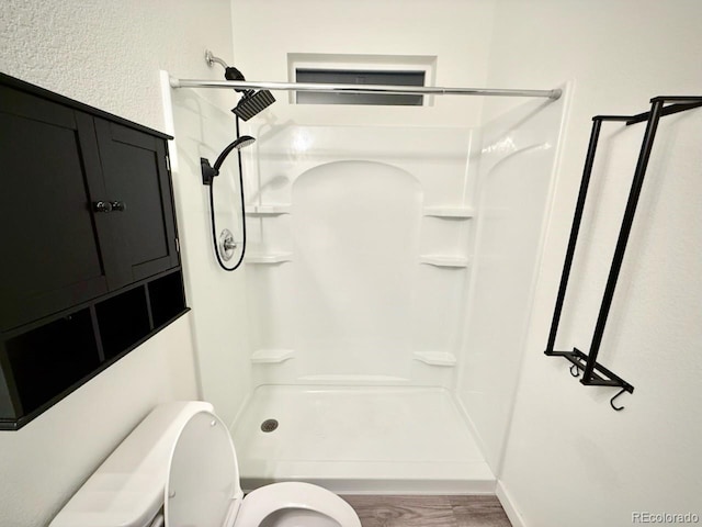 full bathroom with a walk in shower, toilet, and wood finished floors