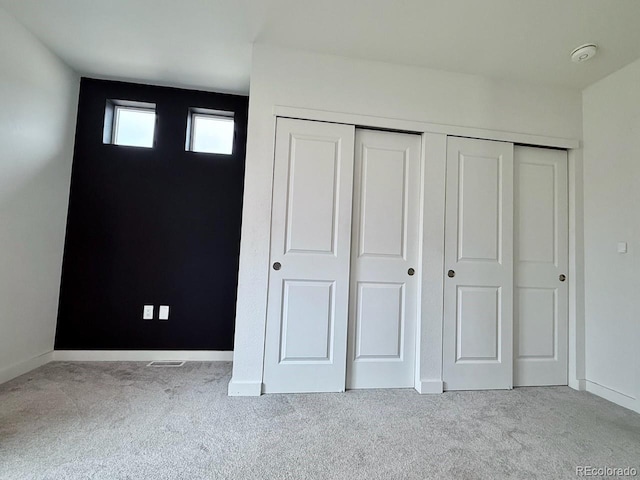 unfurnished bedroom with baseboards, carpet, and a closet