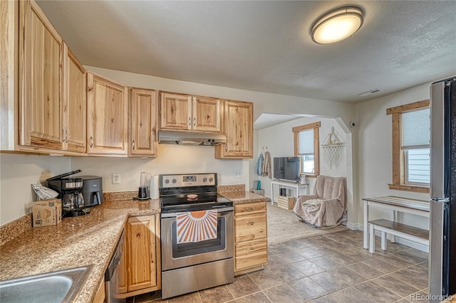 kitchen with sink, stainless steel appliances, light stone countertops, a textured ceiling, and light brown cabinets