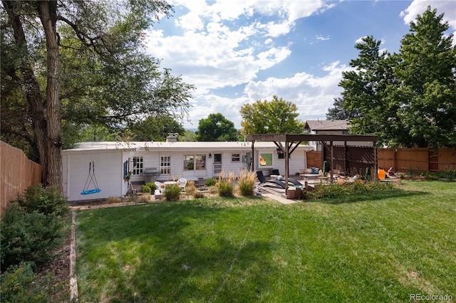 rear view of property featuring a patio area and a yard