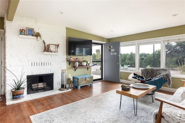 living room featuring wood-type flooring, lofted ceiling with beams, and a fireplace