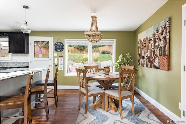 dining area featuring an inviting chandelier and dark hardwood / wood-style floors