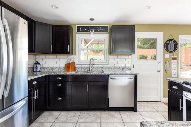 kitchen with stainless steel appliances, a healthy amount of sunlight, backsplash, and sink