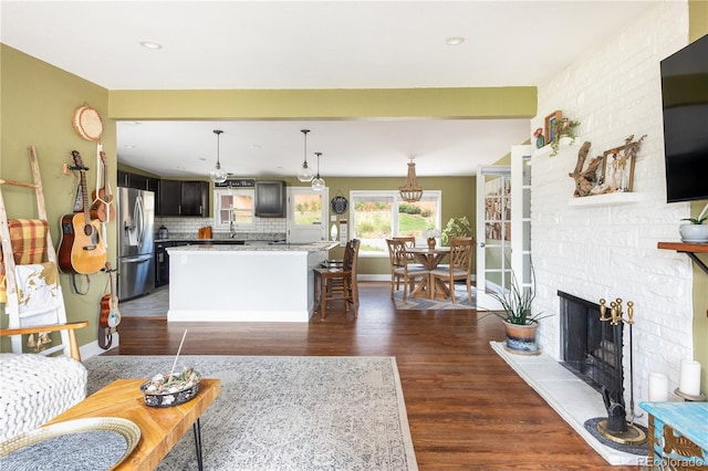 living room with dark wood-type flooring, sink, and a fireplace