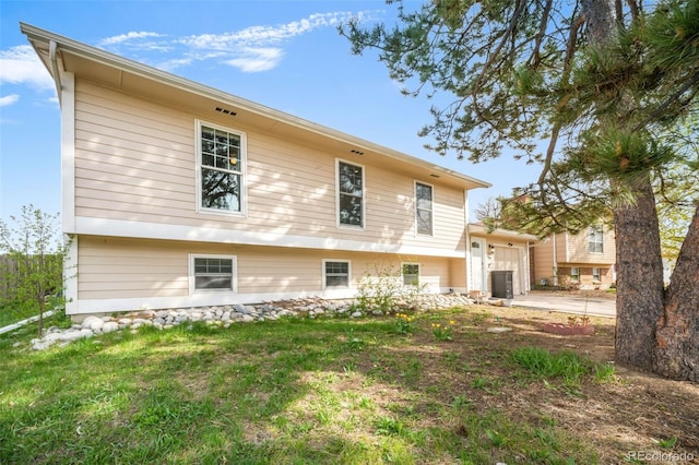 rear view of house featuring an attached garage and concrete driveway