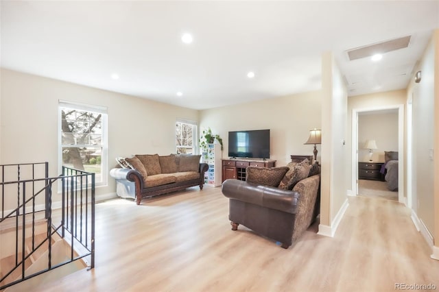 living room featuring light wood-type flooring, baseboards, and recessed lighting