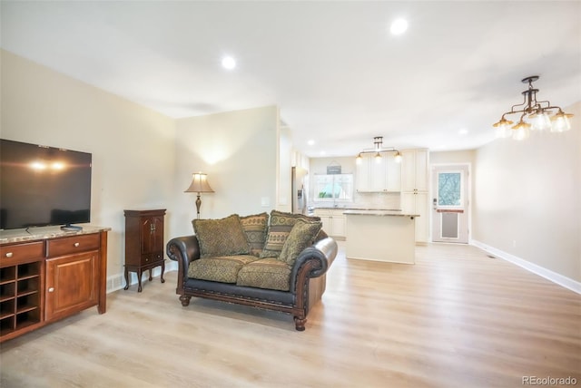 living area featuring light wood finished floors, baseboards, and recessed lighting