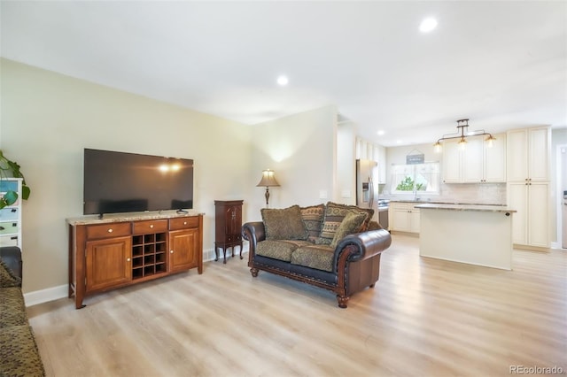 living area featuring light wood-style flooring, recessed lighting, and baseboards