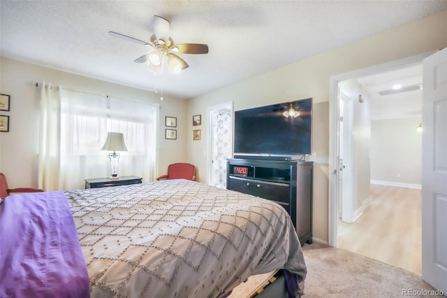 bedroom featuring baseboards, ceiling fan, and light colored carpet