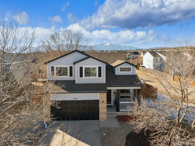 view of front of home with a mountain view, a porch, and a garage