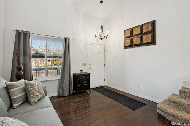 sitting room with a chandelier, a high ceiling, and dark wood-type flooring