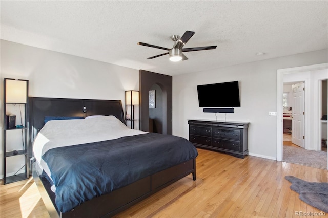 bedroom with ceiling fan, a textured ceiling, and light hardwood / wood-style flooring