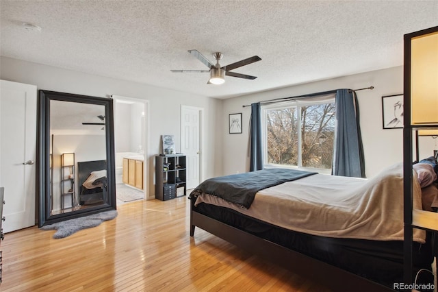 bedroom featuring ceiling fan, ensuite bathroom, light hardwood / wood-style floors, and a textured ceiling