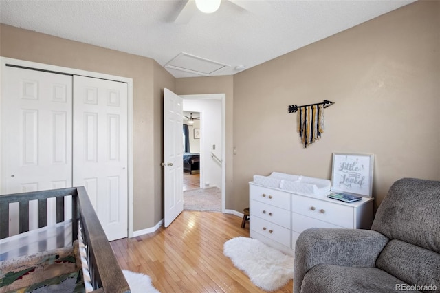 bedroom featuring ceiling fan, a closet, a textured ceiling, and light hardwood / wood-style flooring