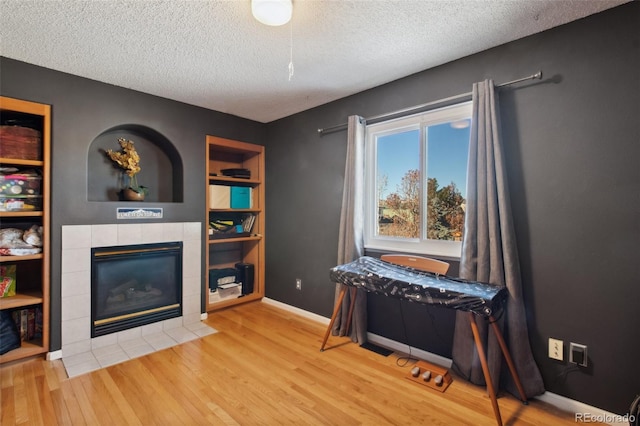 sitting room featuring hardwood / wood-style flooring, a fireplace, and a textured ceiling