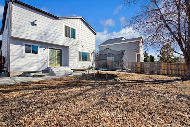 rear view of house featuring a trampoline and a patio