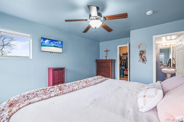 bedroom featuring ceiling fan, a spacious closet, connected bathroom, and a closet