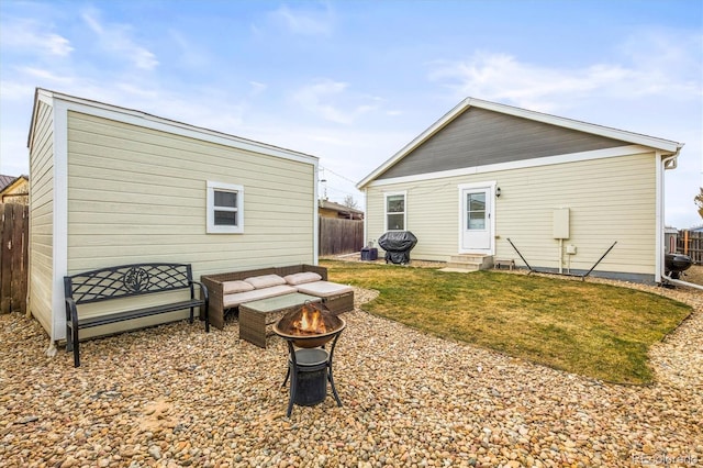 back of property with an outdoor fire pit and a lawn