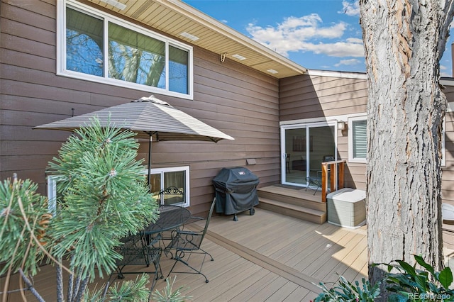 wooden terrace featuring grilling area and outdoor dining space