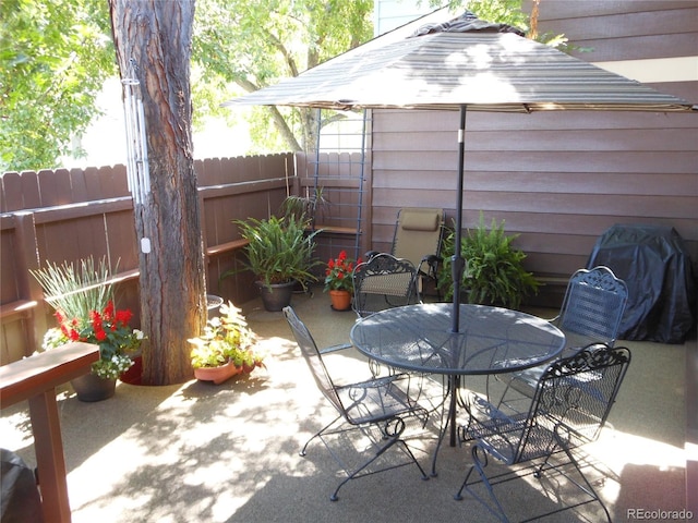 view of patio / terrace featuring a grill, fence, and outdoor dining space