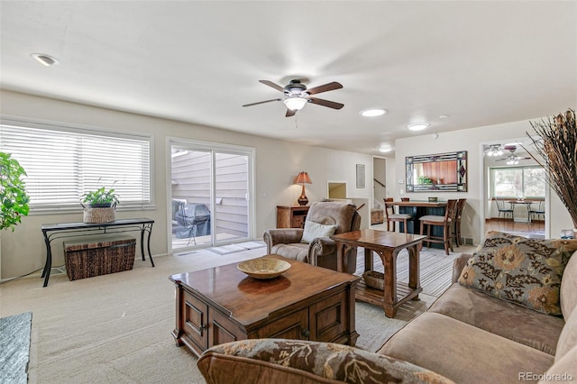 living room featuring a ceiling fan and light colored carpet