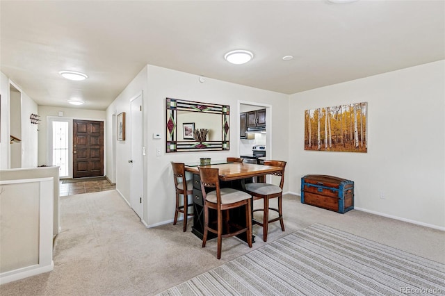 carpeted dining space with baseboards