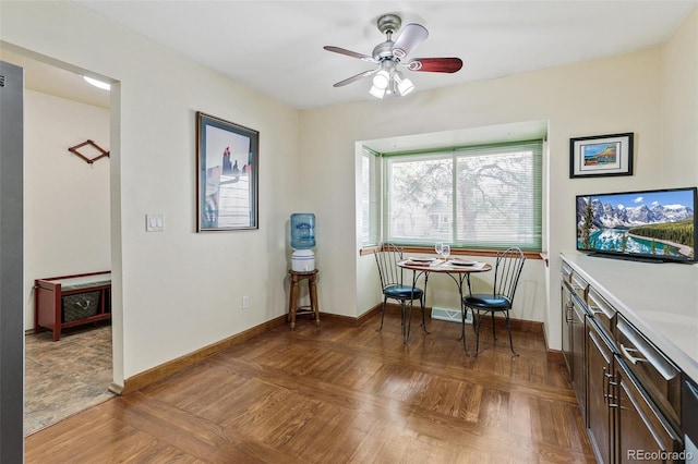 dining room with ceiling fan and baseboards